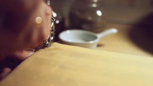 Nahaufnahme eines geformten Teigstücks, das darauf vorbereitet ist, mit einem Nudelholz gerollt zu werden