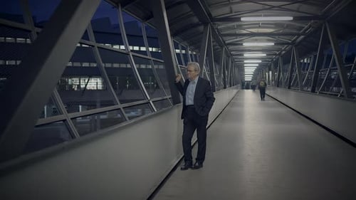 Man in Suit Standing on Urban Walkway at Night