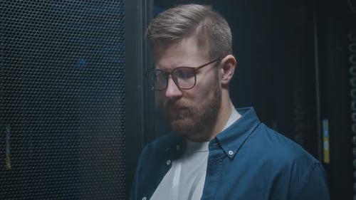 Young Male IT Technician Analyzing Work of Hardware in Data Center