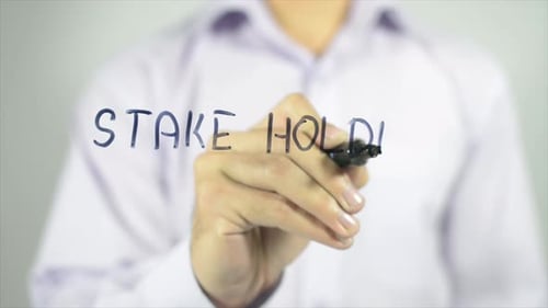 Hand Writes Stakeholder On Clear Surface