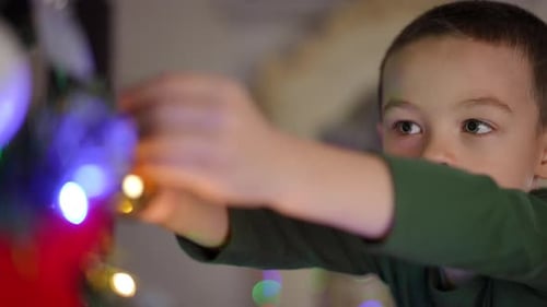 Young Boy Decorating Christmas Tree with Ornament