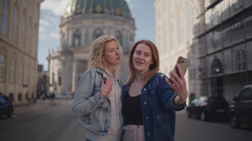 Mujeres tomándose una selfie con la iglesia de Frederik de fondo