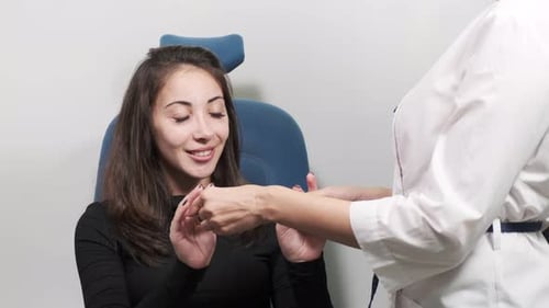 Aufmerksame Augenoptikerin untersucht eine schöne Patientin, überprüft ihr Sehvermögen in einem Augenarzt