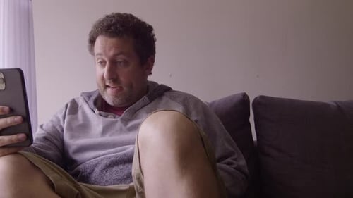 Man Video Chatting on Cell Phone from Couch