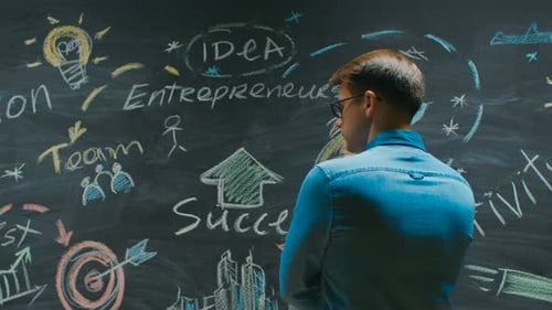 Man Thinking About Business Ideas on Blackboard