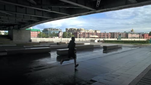 Attractive Fit Man Running Fast Along Big Modern Bridge at Sunset Light Black Man Doing Workout