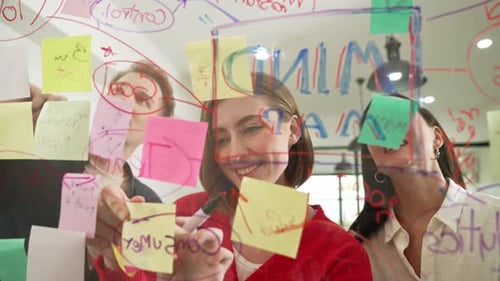 Team Planning and Writing on Glass Whiteboard Together