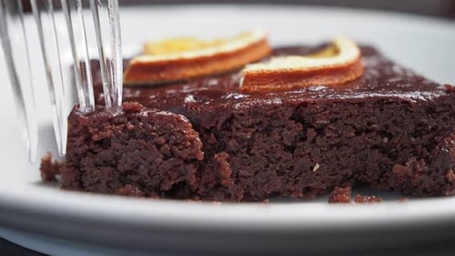 Chocolate Brownie with Orange Slice Being Cut