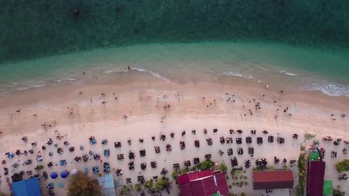 Aerial view of tourists enjoying waves breaking on the shore.