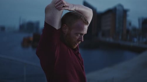 Man Stretching Arms in an Urban Setting