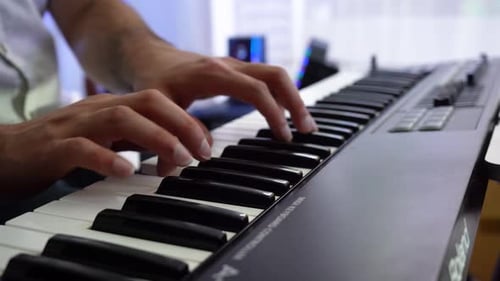 detail shot of the pianist's fingers. musician with piano playing music in studio