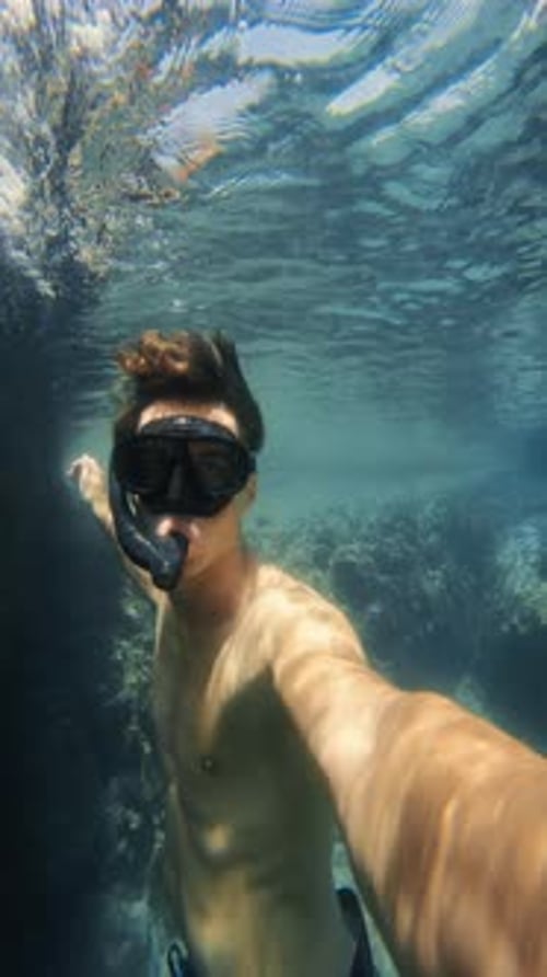 Personne caucasienne faisant de la plongée avec tuba sous l'eau, prenant un selfie, vidéo verticale, plongée en apnée amusante