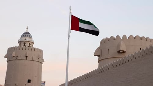 UAE Flag Next to the Traditional Tower in Abu Dhabi UAE
