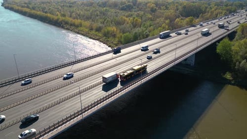 Aerial view of road bridge highway across the river in city area. Lorry is driving on the bridge. Sk