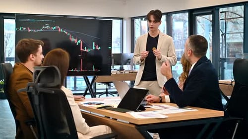Young worker leading business meeting in an office, discussing the topic of cryptocurrencies with ot