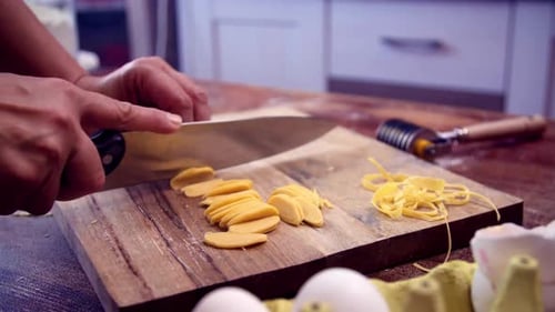Cutting Fresh Pasta Dough on Wooden Board at Home