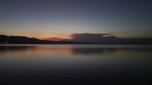 Aerial view over the water of the lake with sunset views and sun reflections
