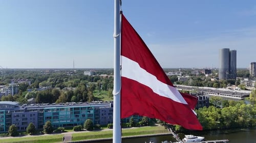 Aerial View of Lithuanian Flag Waving in the Wind with View of Daugava River and Houses on the River