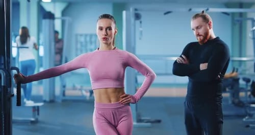 Woman Works Out on Machine at Gym