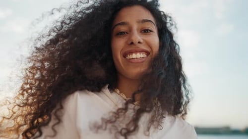 Smiling Woman with Curly Hair Posing Outdoors
