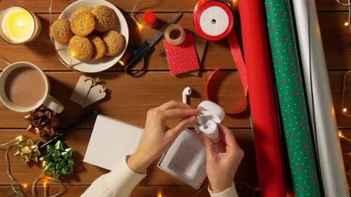 Wrapping Christmas present with electronics and festive accessories