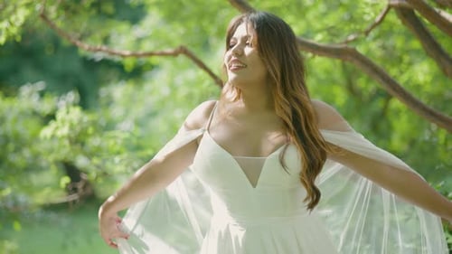Smiling Young Woman Poses in Nature Wearing Dress