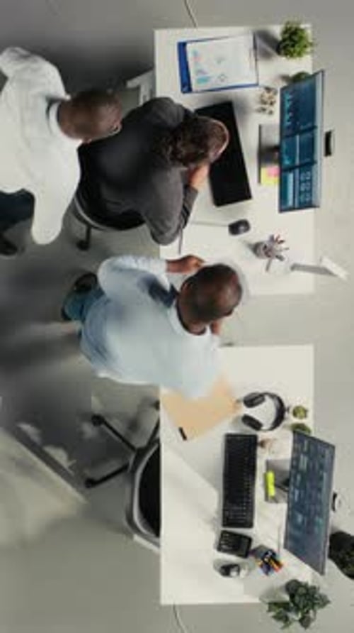 Vertical Video Top Down View of Employees Reviewing Charts and Diagrams During Briefing