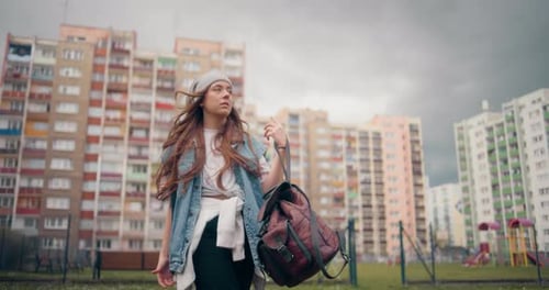 Young Woman Standing Outside Apartment Buildings in City
