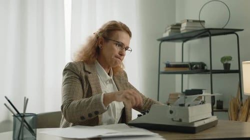 Disappointed Middleaged Female Writer Tearing Paper From Typewriter Into Pieces