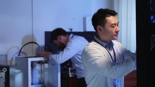Japanese Engineer Coworking in Electronic Research Center Fixing Bugs on 3d Printer Sharing Good