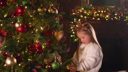 Merry Christmas Xmas Holiday Little Girl Decorating Christmas Tree on Christmas Eve at Home Young