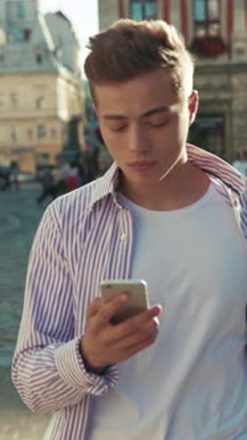 Serious Young Man Walk on Street Use Phone Look Around Portrait Sunlight Work Mobile Gadget Outside