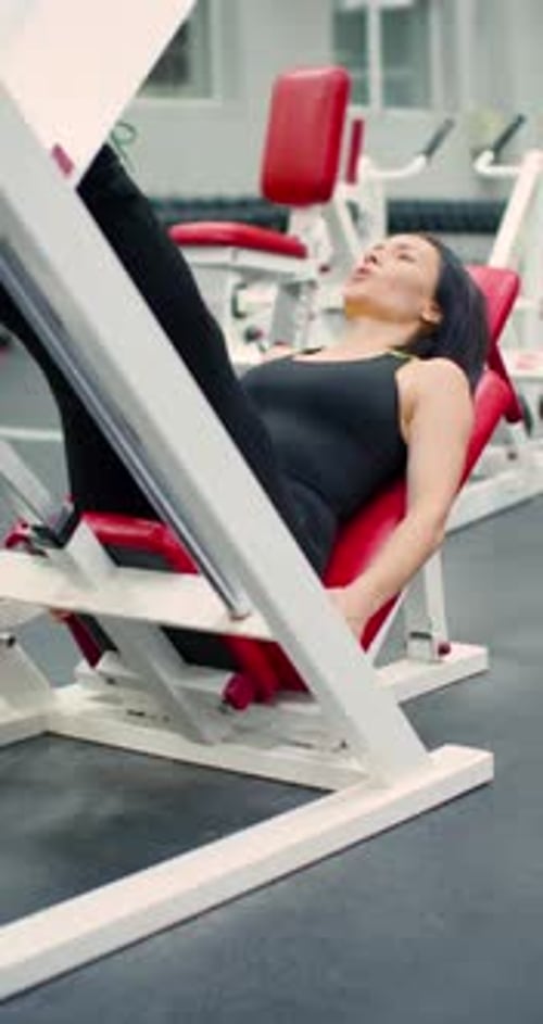 Woman Doing Leg Press Exercise in Gym