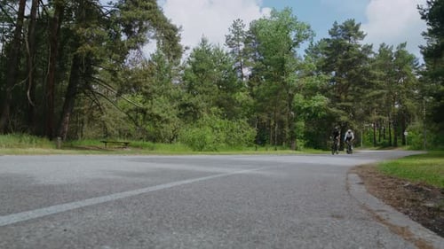 Des athlètes entraînés en survêtement font du vélo sur une route de campagne