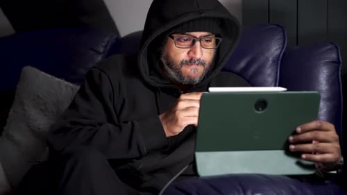 Man Relaxing on Couch with Tablet and Drink