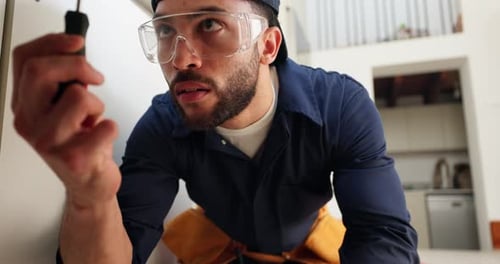 Man with Screwdriver Repairing Equipment Indoors