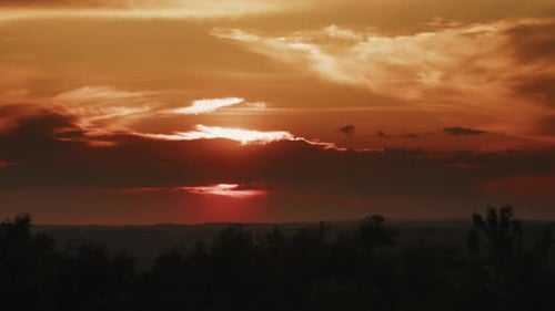 Dramatic Sunset Over Wooded Landscape