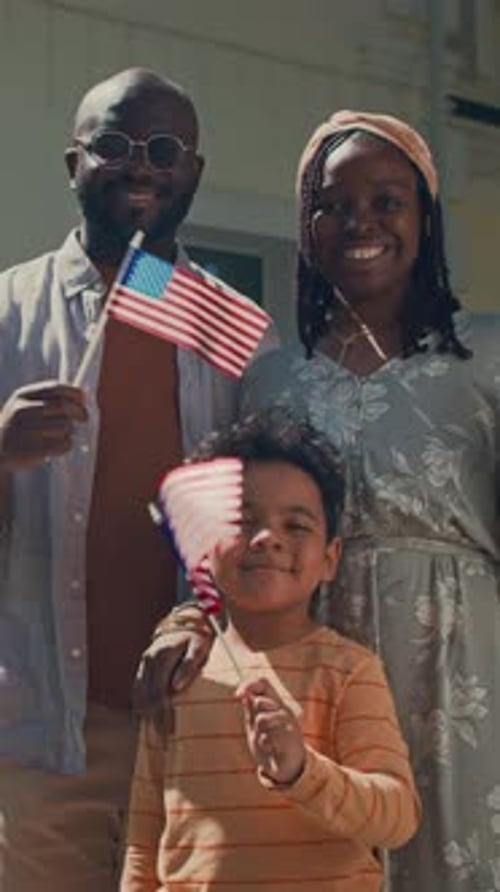 Smiling Family Celebrates Holding American Flags