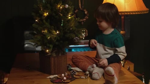 Child Decorating a Small Christmas Tree at Home