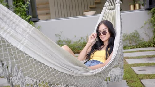 Woman Relaxing in Hammock in Beautiful Yard