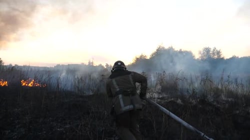 Firefighter Battling Wildfire at Sunset
