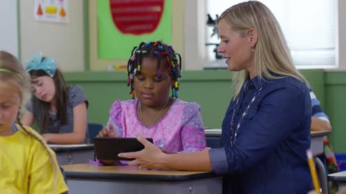 Teacher and Student Use Digital Tablet in School Classroom African