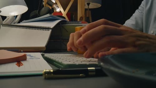 Man's hands typing on keyboard at desk