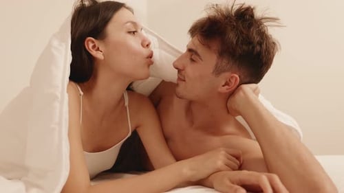 Couple affectueux profitant d'un moment intime sous le drap