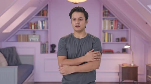 Young Adult with Folded Arms in Bedroom