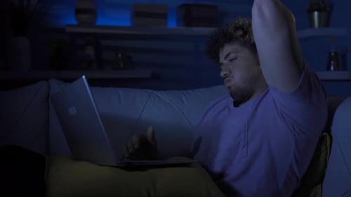 Young Adult Typing on Laptop Late at Night