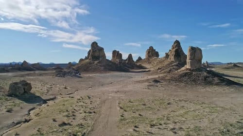 Low aerial view moving quickly toward the Trona Pinnacles rock formations on a sunny morning