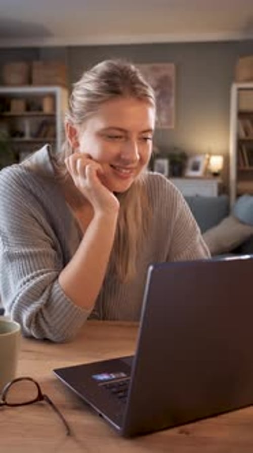 Woman Uses Laptop at Table at Home