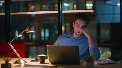Man Working Late At Computer in Modern Office