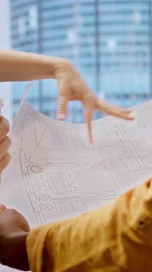 Vertical Video Real Estate Expert Reviewing Construction Plans for a New Urban Office